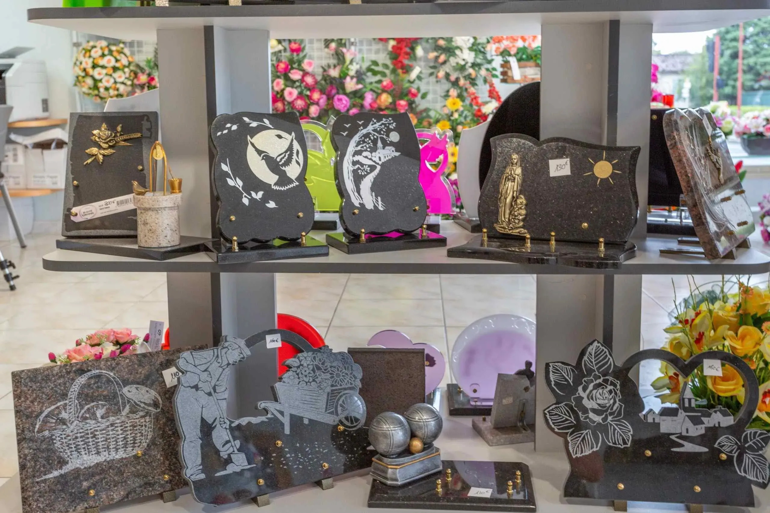 Étagères d'exposition présentant un choix de plaques funéraires gravées aux motifs personnalisés