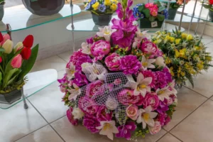 Composition florale funéraire volumineuse aux nuances de rose et de blanc pour dessus de tombe