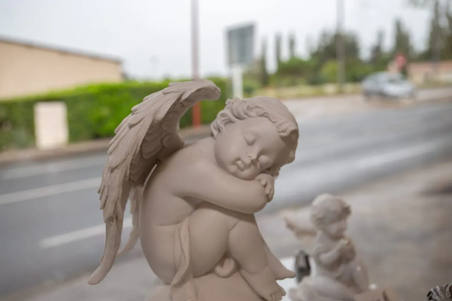 Statuette d'ange endormi en pierre sculptée utilisée comme ornement funéraire